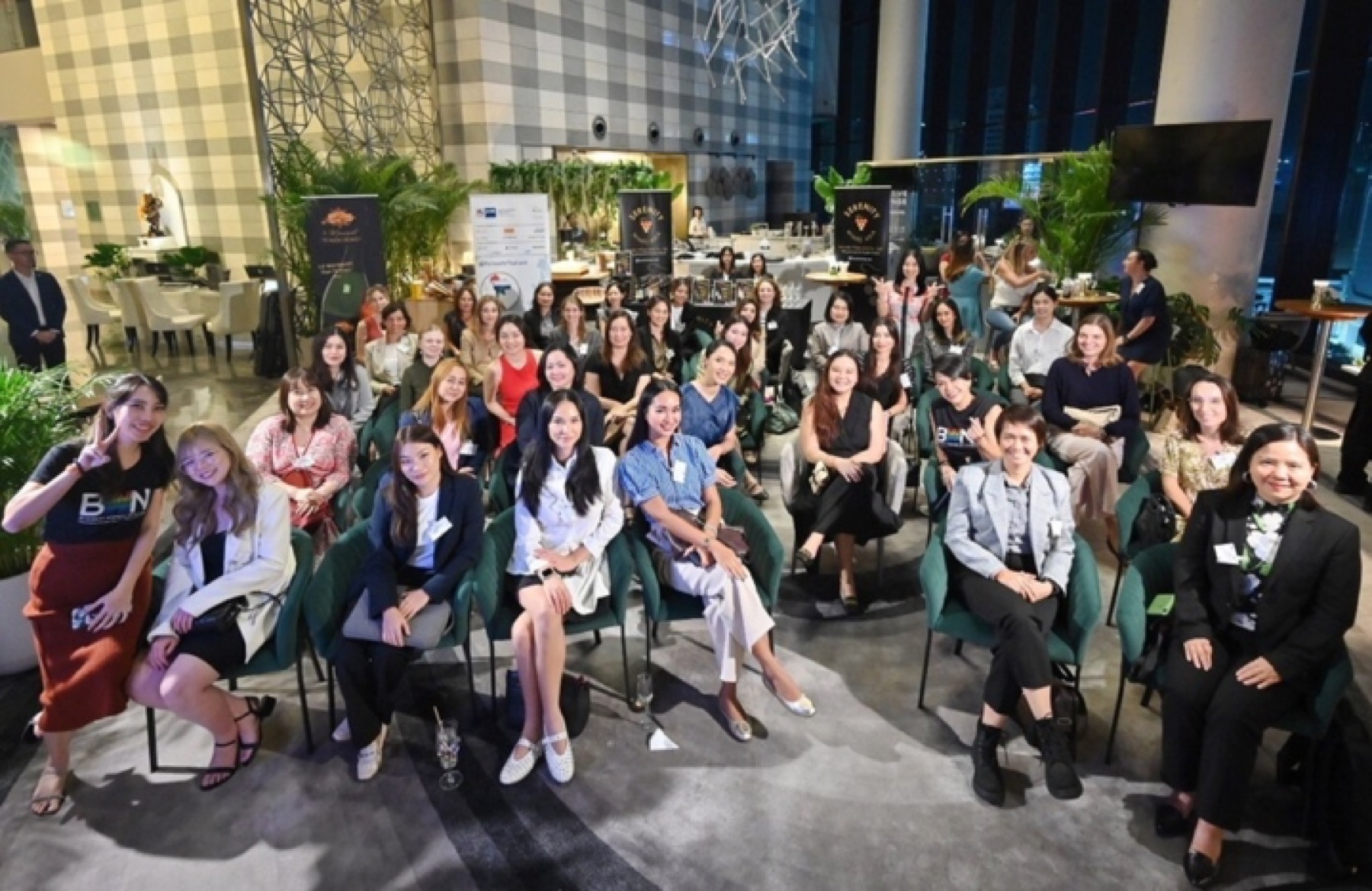 Members of the GTCC Business Women Network seated for a talk in a Bangkok hotel atrium.